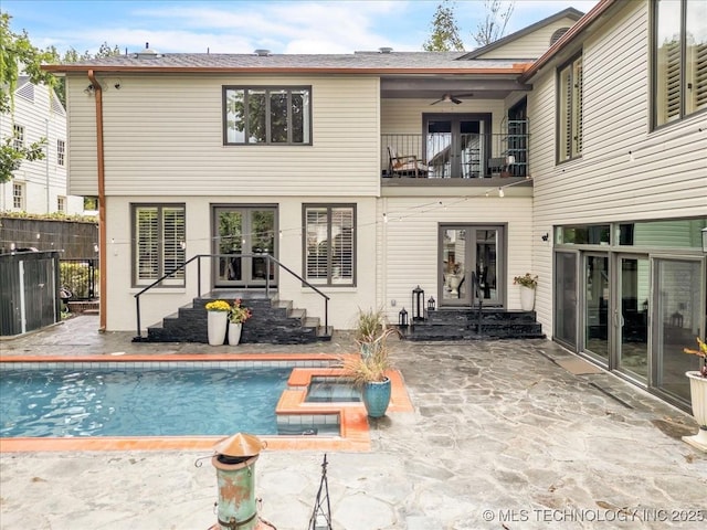 rear view of property with a fenced in pool, french doors, a balcony, and a ceiling fan