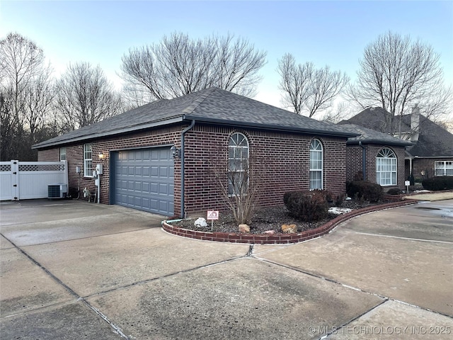 view of side of property featuring a garage and central air condition unit