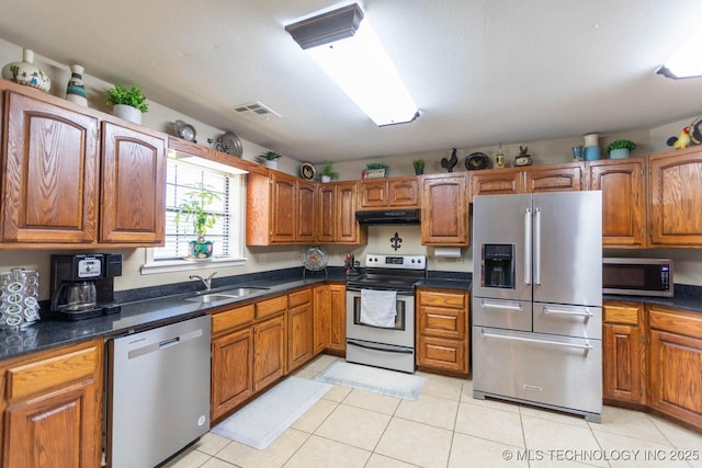 kitchen with light tile patterned floors, sink, and stainless steel appliances