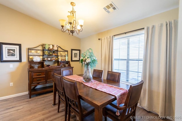 dining space with a chandelier and hardwood / wood-style flooring