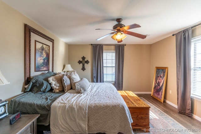 bedroom featuring ceiling fan, wood-type flooring, and multiple windows