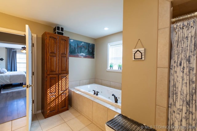 bathroom with tiled bath, plenty of natural light, tile patterned floors, and ceiling fan