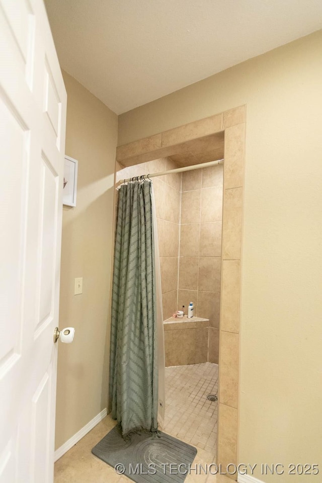 bathroom with tile patterned flooring and walk in shower