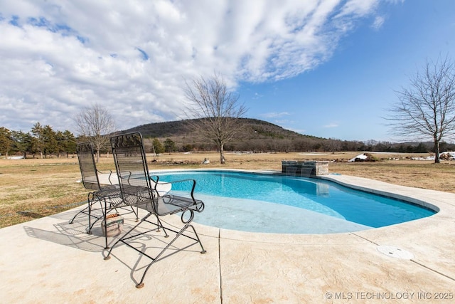 view of pool featuring a mountain view and a patio