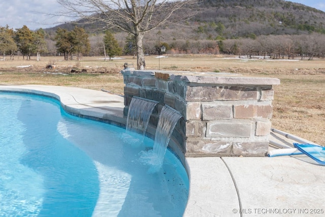 view of swimming pool with pool water feature