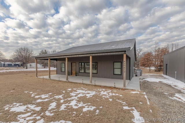 rear view of house featuring covered porch