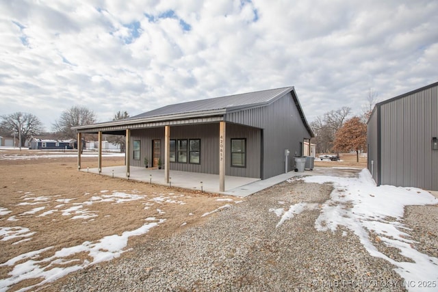 snow covered house featuring covered porch