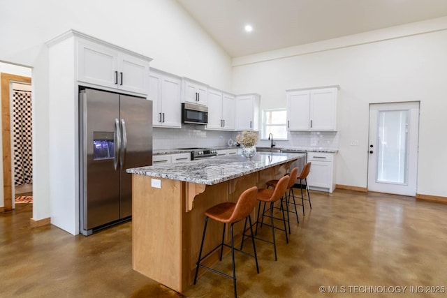 kitchen featuring white cabinetry, stainless steel appliances, and a center island