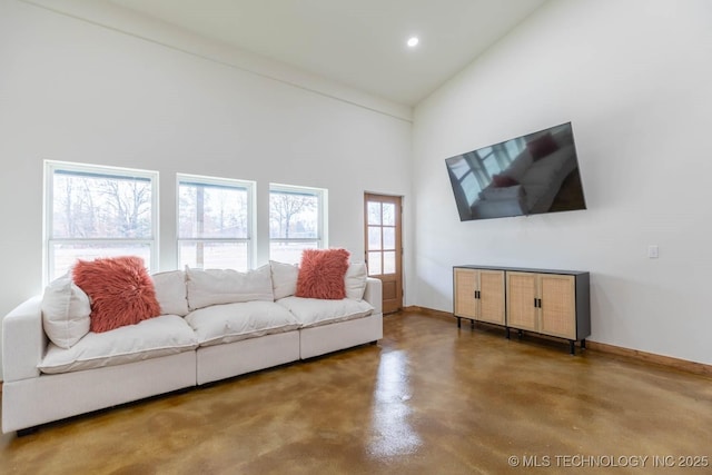 living room featuring concrete floors and a towering ceiling