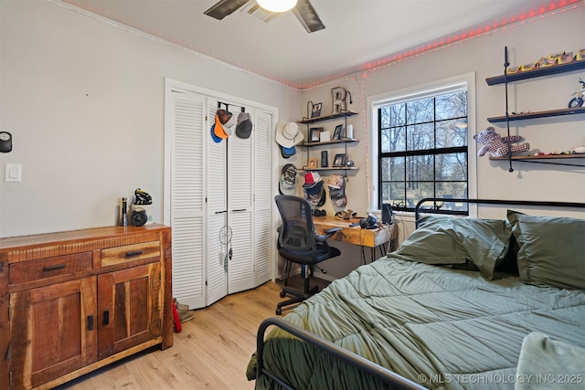 bedroom with ceiling fan, a closet, and light hardwood / wood-style floors