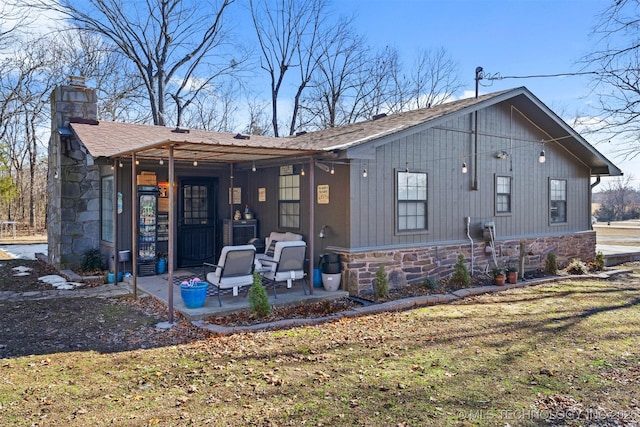 rear view of house with a lawn and a patio