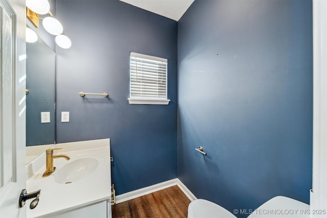 bathroom featuring toilet, hardwood / wood-style flooring, and vanity