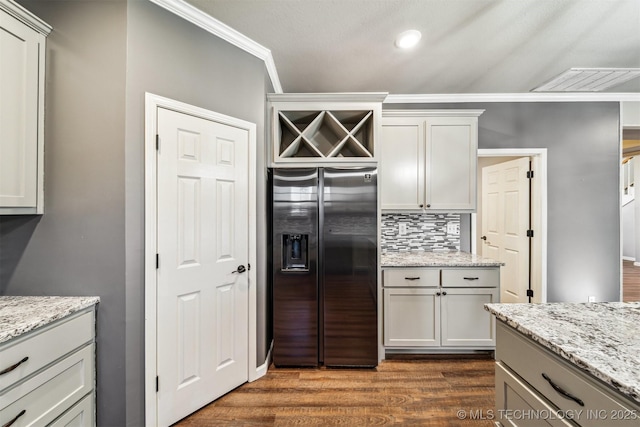 kitchen featuring stainless steel refrigerator with ice dispenser, light stone countertops, decorative backsplash, and crown molding