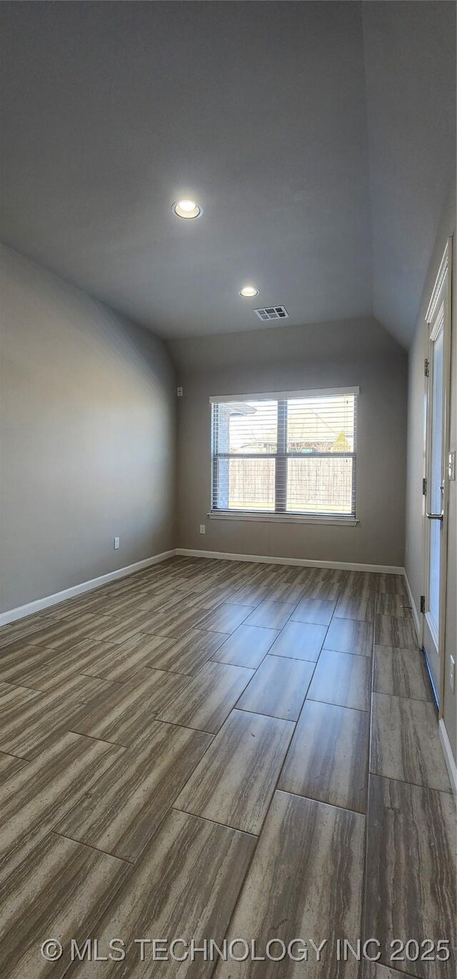 unfurnished room featuring vaulted ceiling