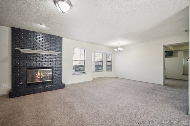 unfurnished living room featuring carpet flooring, a brick fireplace, a textured ceiling, and an inviting chandelier