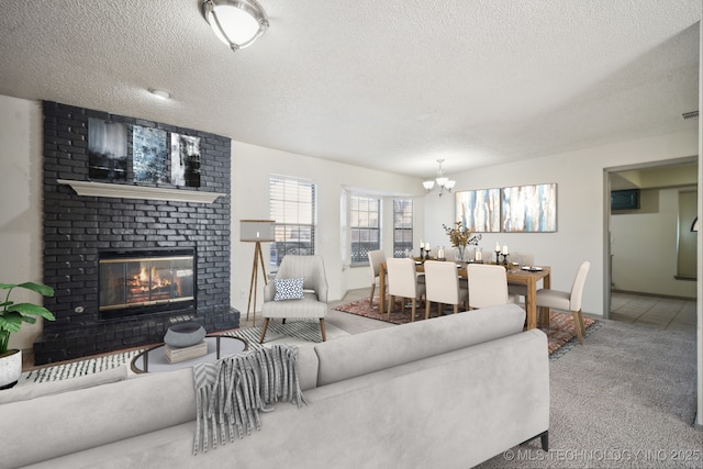 living area featuring a brick fireplace, a notable chandelier, carpet floors, and a textured ceiling