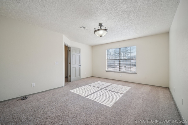 carpeted spare room featuring visible vents and a textured ceiling