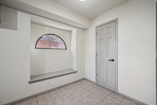 interior space with baseboards and a textured ceiling