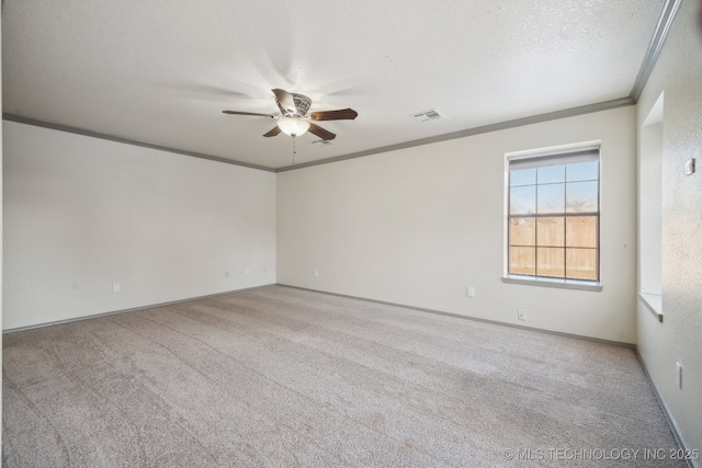 empty room with a textured ceiling, carpet, visible vents, and ornamental molding