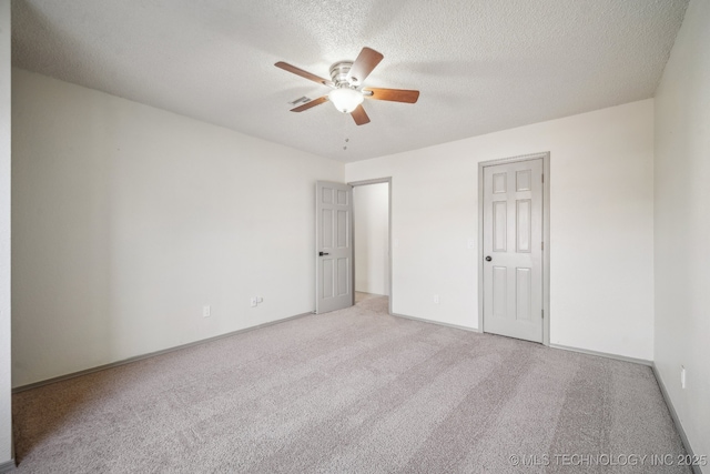 unfurnished bedroom featuring a ceiling fan, carpet, baseboards, and a textured ceiling