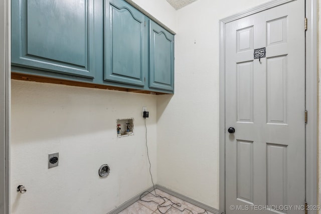 clothes washing area with cabinet space, hookup for an electric dryer, hookup for a washing machine, and baseboards