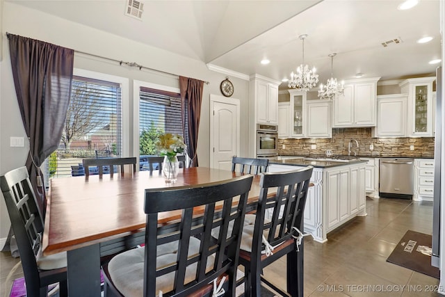 tiled dining room with vaulted ceiling and a notable chandelier