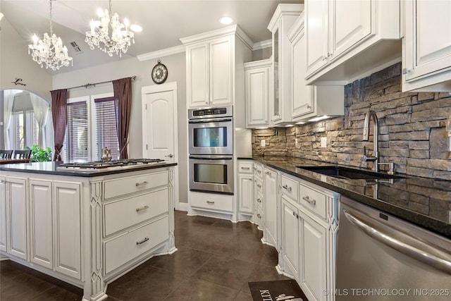 kitchen featuring dark tile patterned flooring, decorative light fixtures, white cabinetry, stainless steel appliances, and sink