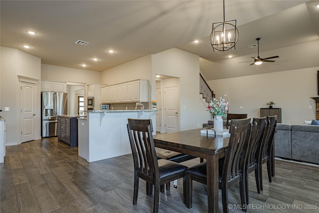 dining room with dark wood-type flooring, sink, and ceiling fan with notable chandelier