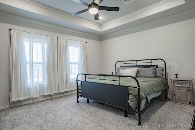 bedroom with ceiling fan, light colored carpet, a tray ceiling, and ornamental molding