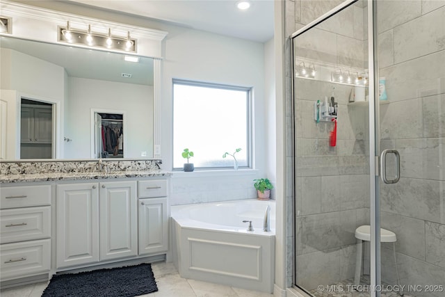 bathroom featuring plus walk in shower and vanity