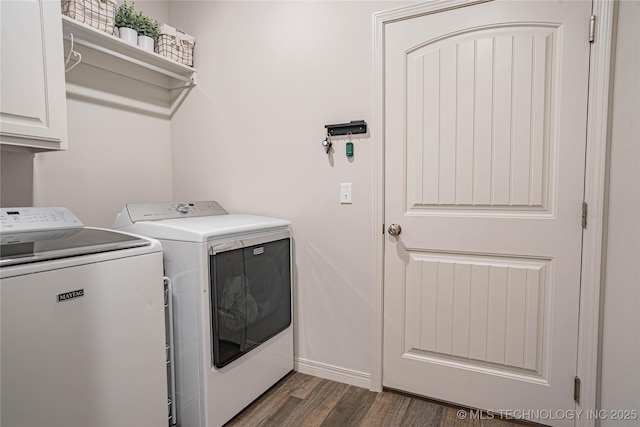 washroom with washing machine and dryer, dark wood-type flooring, and cabinets