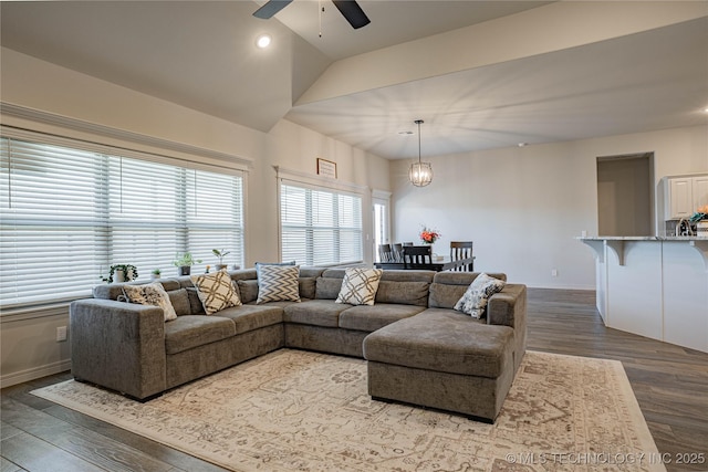 living room with ceiling fan, vaulted ceiling, and dark hardwood / wood-style floors