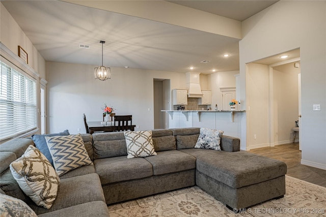 living room featuring an inviting chandelier and light hardwood / wood-style flooring