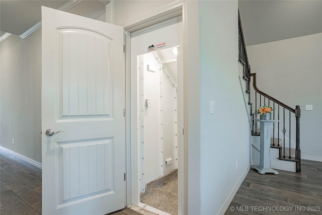 hallway featuring ornamental molding and dark hardwood / wood-style flooring