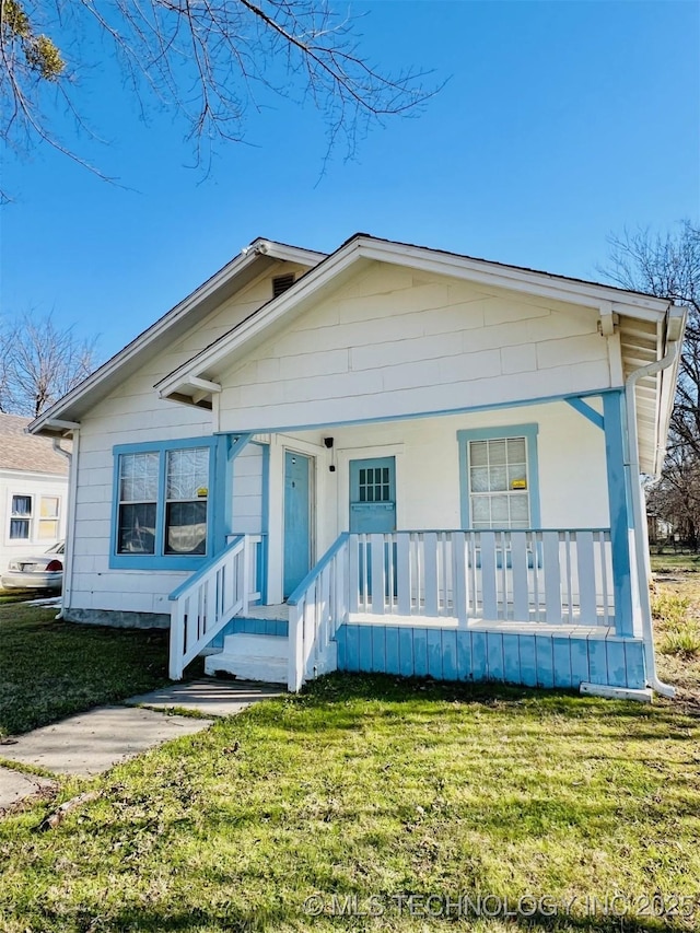 view of front of home with covered porch and a front lawn