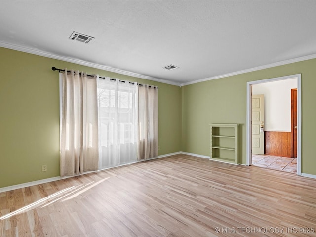 unfurnished room with light wood-type flooring, ornamental molding, and a textured ceiling