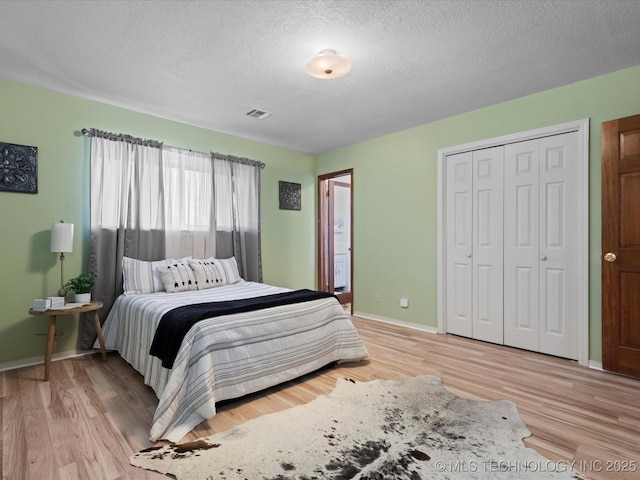 bedroom featuring a textured ceiling, a closet, and light hardwood / wood-style floors