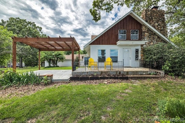 back of house featuring a pergola, a patio area, and a lawn