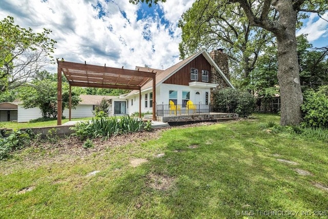 back of property with a pergola and a lawn