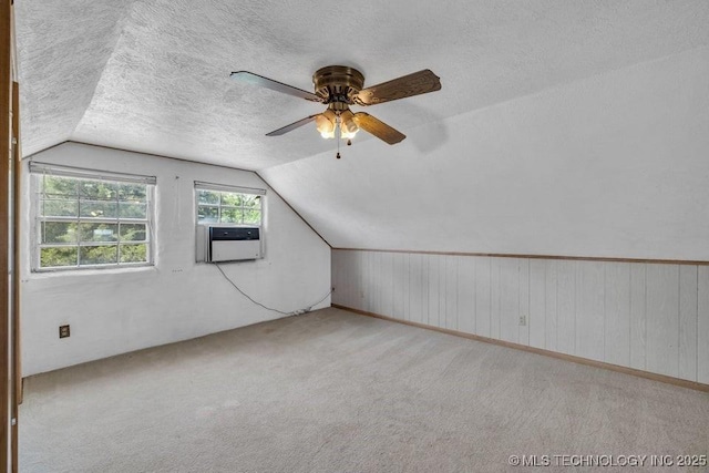 additional living space featuring a textured ceiling, ceiling fan, lofted ceiling, and cooling unit