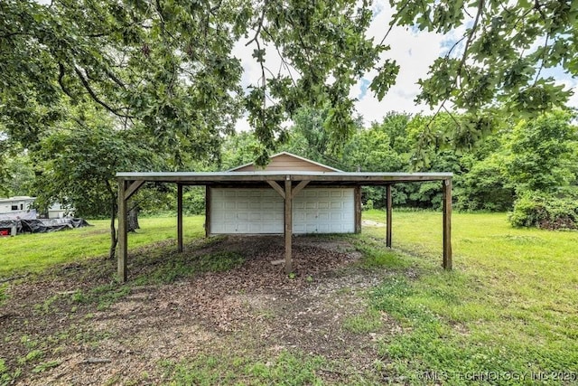 view of yard featuring an outbuilding, a carport, and a garage