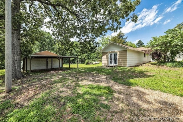 view of yard featuring french doors and a carport