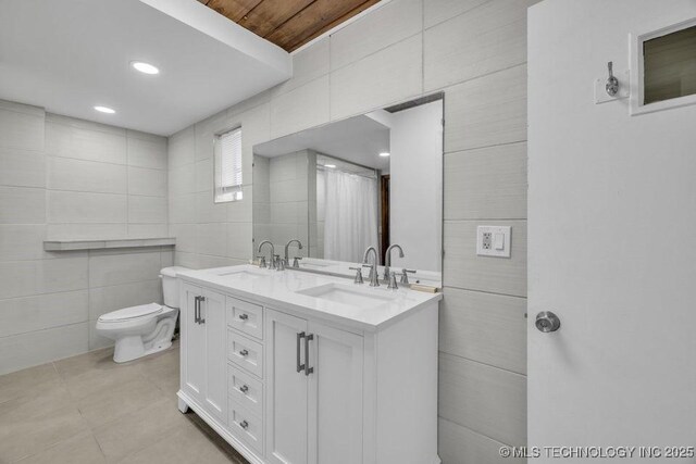 bathroom featuring tile walls, toilet, and vanity