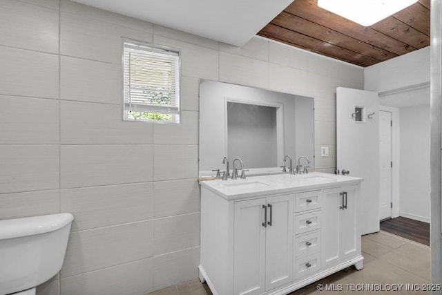 bathroom featuring toilet, wooden ceiling, tile walls, tile patterned floors, and vanity