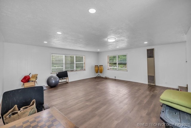 sitting room with dark wood-type flooring and a textured ceiling