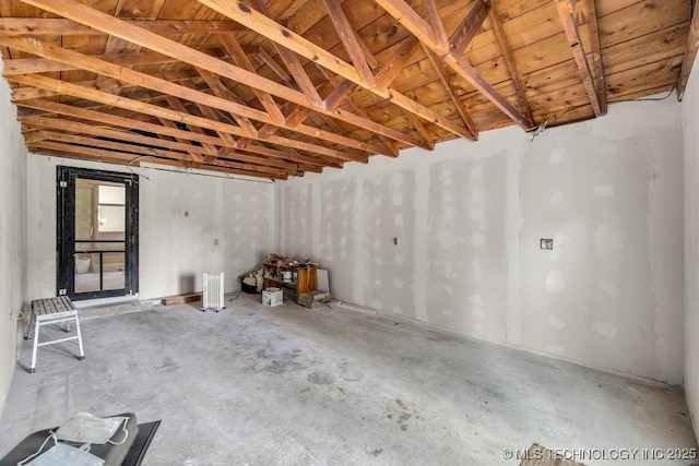 interior space with lofted ceiling and concrete flooring