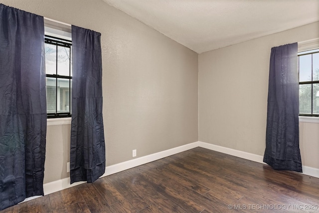 unfurnished room featuring vaulted ceiling and dark wood-type flooring