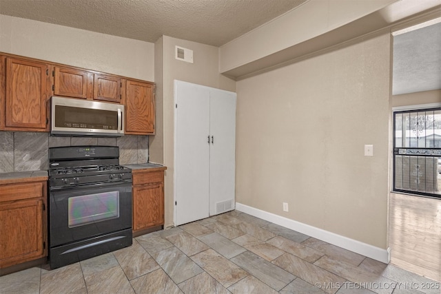 kitchen with tasteful backsplash, a textured ceiling, and black range with gas cooktop