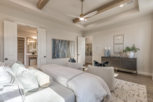 bedroom with a fireplace, ceiling fan, light hardwood / wood-style floors, and a tray ceiling