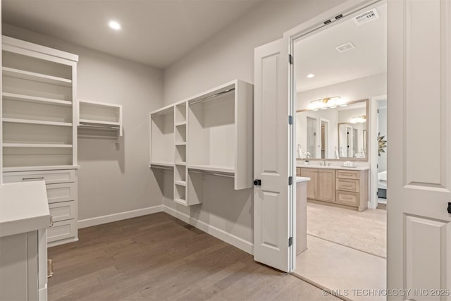 walk in closet featuring light hardwood / wood-style floors and sink